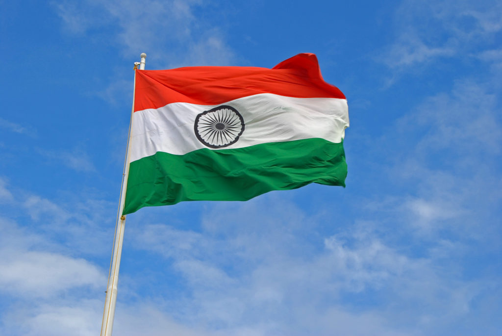 The Indian Flag flying high on top of a flag pole